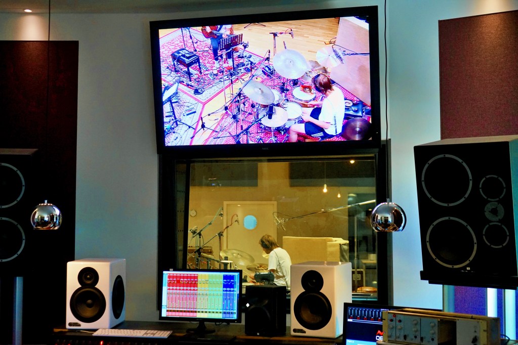 Bildschirm zeigt Schlagzeuger im Studio